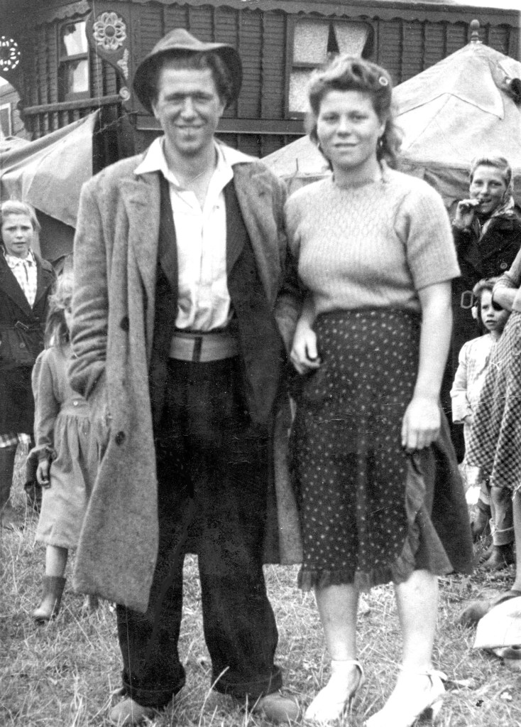 A black and white photo of a Traveller couple, dressed smartly and smiling